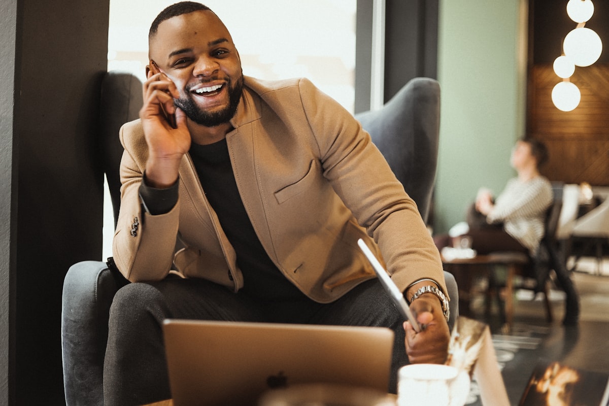 A consultant laughing on a phone call at his laptop